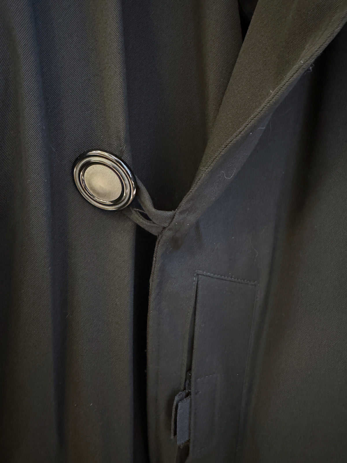 Brandsamsara Jean Paul Gaultier black coat featuring a prominent circular button and structured fabric detail
