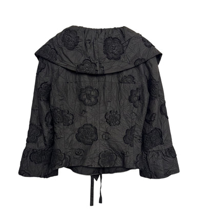 Brandsamsara black textured shirt with floral embroidery and ruffled cuffs, featuring a tie closure at the hem.