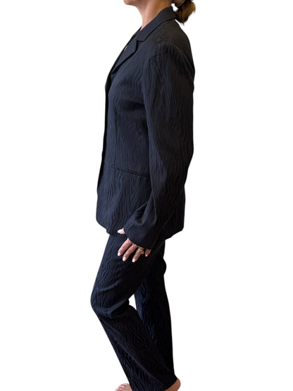 Brandsamsara Max&Co suit in black acetate blend with a subtle textured wave pattern, worn by a model, side view.