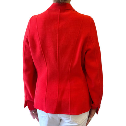 Brandsamsara orange long sleeve Escada jacket with textured fabric, back view on a person wearing white trousers